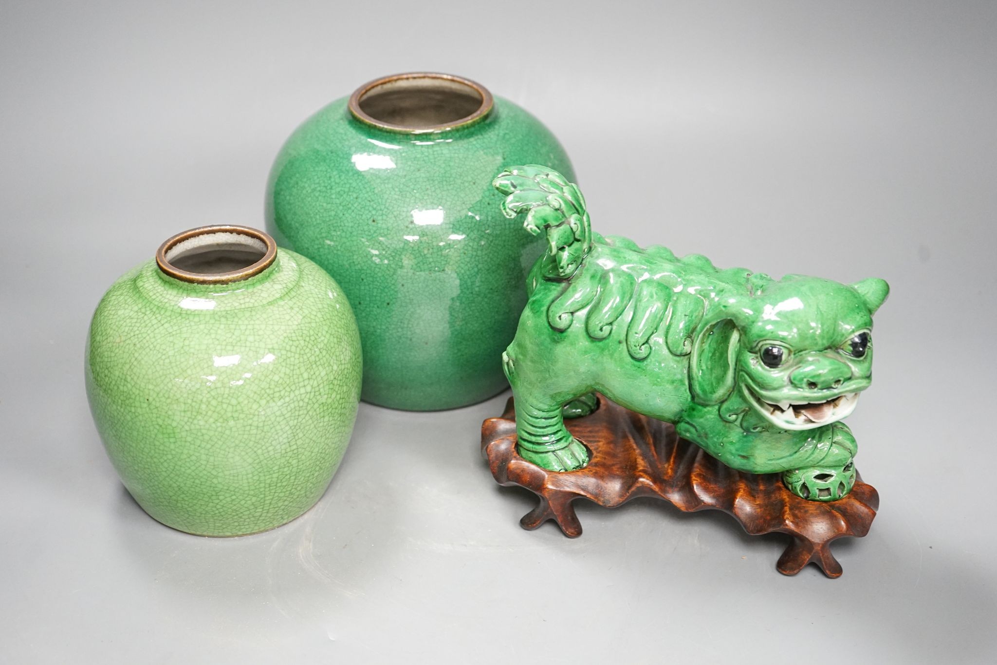 A 19th century Chinese green glazed model of a lion-dog, and two green crackle glaze jars, tallest 16cm